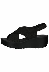 Black wedge sandals with a textured fabric upper, featuring crisscross straps and a rear ankle strap. Textured sole for added grip.
