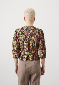 Blusa floreale nera, con motivi di fiori colorati, maniche a palloncino a tre quarti e retro arricciato con dettaglio di legatura in vita.