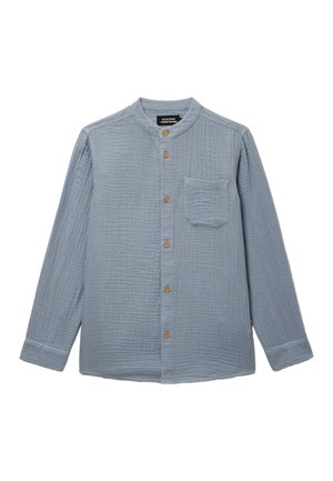 Chemise à manches longues bleu clair texturée avec boutons en bois, col mandarin et poche poitrine, étalée à plat sur un fond blanc.
