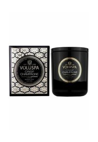 Mustan kynttilän tyylikkäässä astiassa, jossa on etiketti "Raikas samppanja". Pakkaus on koristeltu monimutkaisilla hopea- ja mustavarjoilla kuvioilla, ja siinä on pyöreä logo.