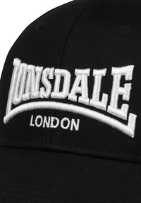 Căciulă de baseball neagră, cu un text alb brodat proeminent "LONSDALE" și detalii "LONDON", fabricată dintr-un material texturat, cu un vârf curbat.