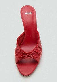 Chaussure slip-on en cuir rouge avec un bout arrondi, un design plissé et un nœud décoratif à l'avant. Texture lisse, talon haut.