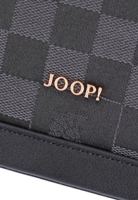 Sort og gråternet tekstilpung med et rose gold "JOOP!" logo, en glat sort læderbund og syningsdetaljer.