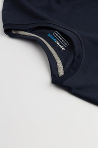 Námořnická modrá košile s krátkým rukávem a kulatým výstřihem, s kontrastním šedým texturovaným lemem a štítkem na vnitřní straně výstřihu.