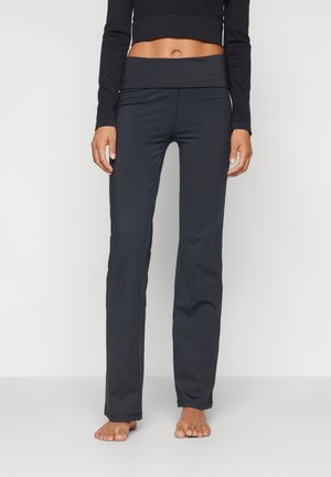 Black athletic pants with a wide, folded waistband, smooth fabric, and a fitted silhouette, designed for comfort and flexibility.