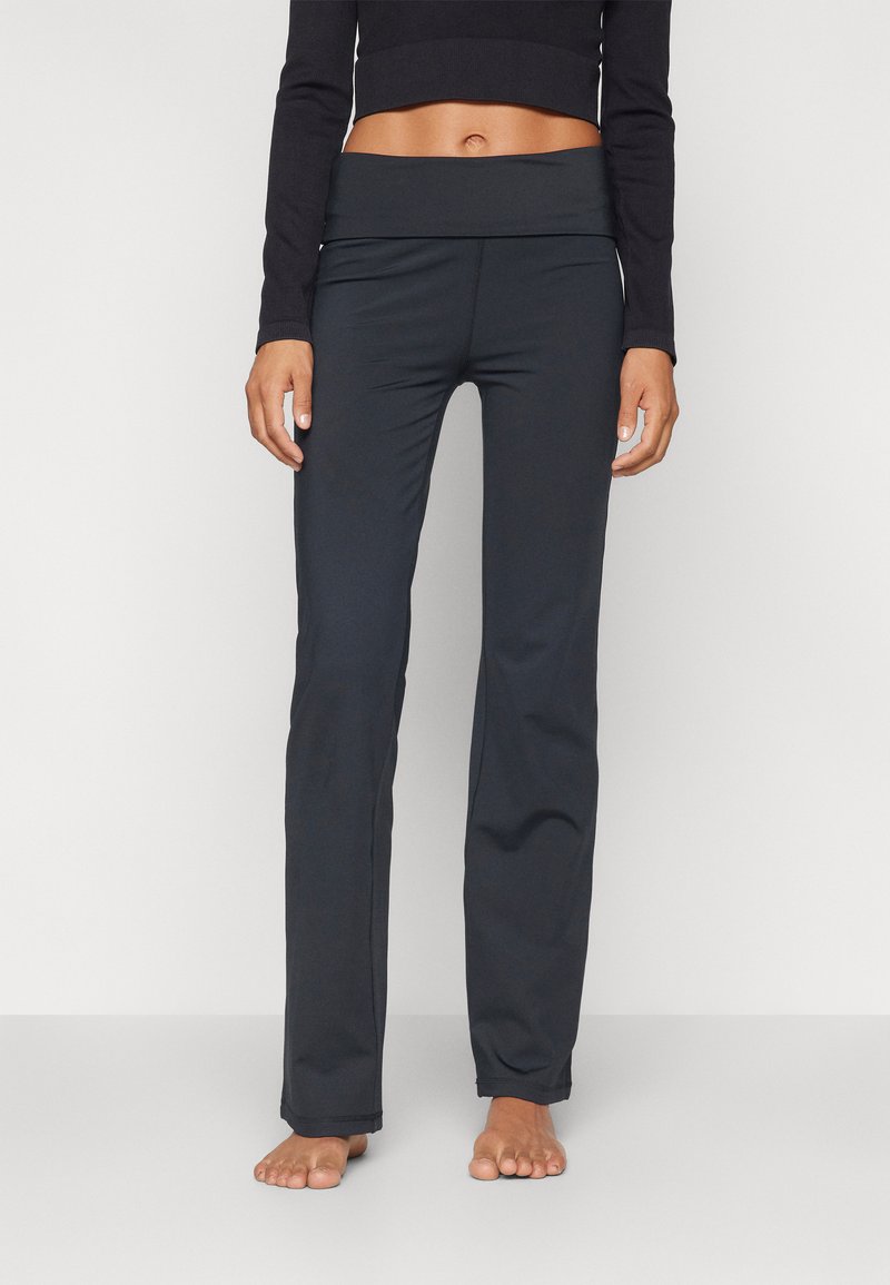 Black athletic pants with a wide, folded waistband, smooth fabric, and a fitted silhouette, designed for comfort and flexibility.