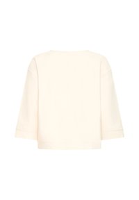 Kreemikas värvi pikkade varrukatega särk karbikujulise lõike ja laiade varrukatega, näidatud tagant tavalise valge tausta peal.