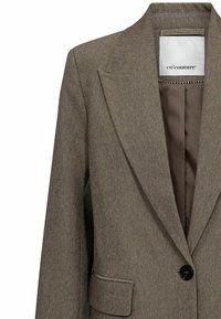 Hnědý strukturovaný blazer s klopou, jedním černým knoflíkem a kapsou. Podšívka v jednobarevné hnědé barvě.