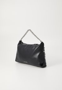 Sac à main en cuir noir avec une bandoulière en chaîne, présentant une finition lisse et des clous argentés décoratifs sur un côté. Fermeture zippée.