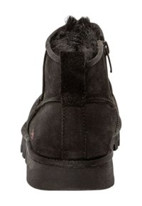 Sorte ruskinds ankelstøvler med en struktureret overdel, der har lynlås lukning og en gummisål, fremhævet af en kort pelslignende kant bagpå.