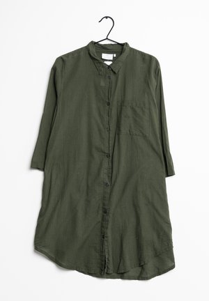 Chemise-robe longue vert olive avec boutons, poche poitrine et manches trois-quarts, suspendue sur un cintre noir contre un fond blanc.