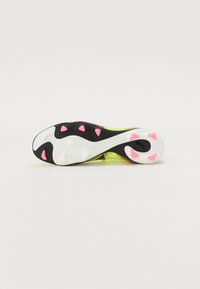 Shoe sole with a prominent black and white pattern, featuring pink rubber accents and textured grip points. Lightweight and flexible design.