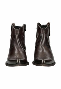 Hnědé kožené kotníkové boty se zipem, obklopené zakřivenými švy a texturovanými stélkami, vystavené špičkou k špičce.