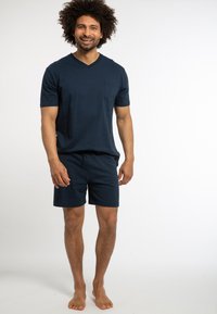 Marineblaues, kurzärmliges V-Ausschnitt-T-Shirt mit Brusttasche, kombiniert mit passenden Shorts. Bequemes Material mit lockerer Passform.