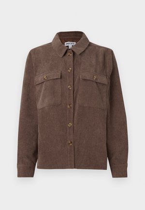 Brązowa sztruksowa kurtka koszulowa z długim rękawem, z zapięciem na guziki i dwiema kieszeniami na guziki na piersiach, wyeksponowana na białym tle.