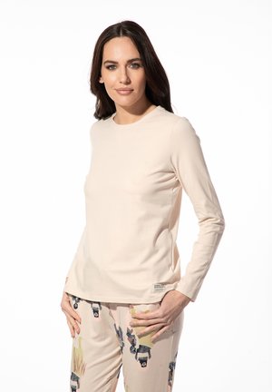 Licht beige langarmshirt van zacht materiaal, met een ronde halslijn, zijnaadzakken en een klein logo-label aan de zoom.