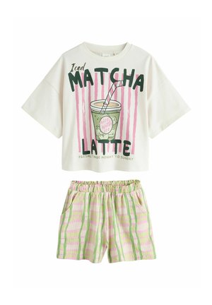 Weißes kurzärmeliges Oberteil mit der Aufschrift "Iced Matcha Latte" und einem Getränke-Grafik, kombiniert mit rosa-grün gestreiften Shorts mit elastischem Bund.