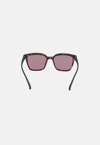 Ochelari de soare tortoise brown cu lentile pătrate. Au o nuanță roz și brațe negre subțiri. Design contemporan.