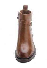 Bottillon en simili cuir marron avec un bout rond, une semelle plate, une fermeture éclair sur le côté et une bande décorative avec un détail de boucle en métal.