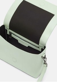Borsa a tracolla in pelle verde menta con interno in tessuto nero. Presenta una tasca con zip, chiusura magnetica e tracolla regolabile.