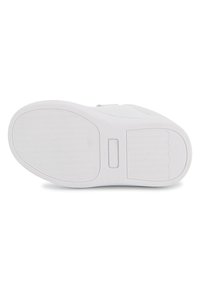 Semelle de chaussure blanche avec des motifs d'adhérence texturés et une indentation rectangulaire au centre, vue par le dessous.
