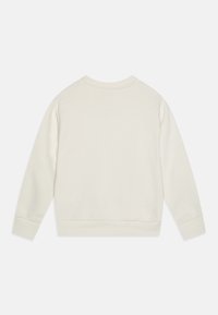 Felpa color crema con scollo rotondo, polsini e orlo a costine, caratterizzata da una superficie liscia e da un design semplice e minimalista.