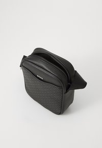 Borsa in pelle nera con un motivo texturizzato. Presenta doppie cerniere, una parte superiore arrotondata e una maniglia laterale. Design compatto, adatta per gli essenziali.