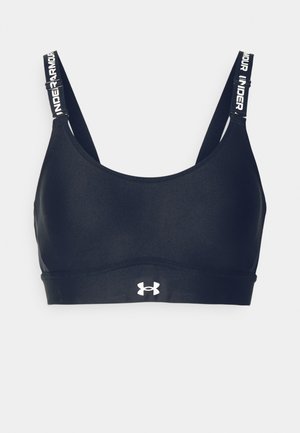 Zwarte sportbeha van gladde stof, met brede bandjes die merknaam bevatten, en een wit logo aan de voorkant. Eenvoudig, naadloos ontwerp zonder sluitingen.