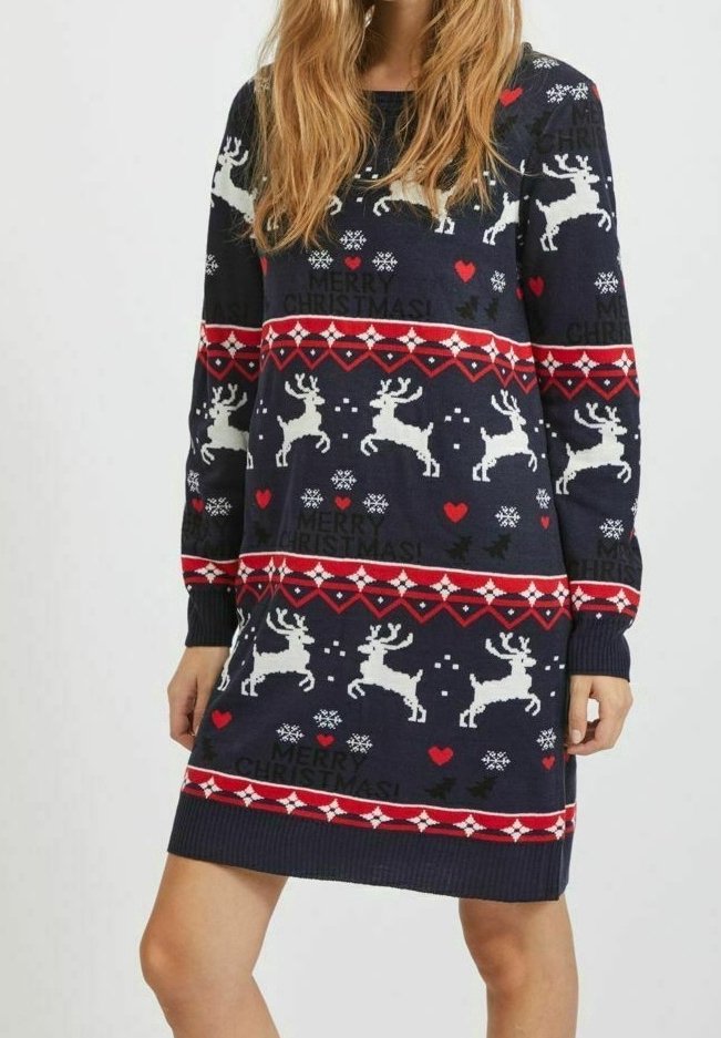 Robe pull de Noël tricotée avec une base bleu marine, motifs de rennes et flocons de neige en blanc, rouge et accents blancs, avec des poignets côtelés.
