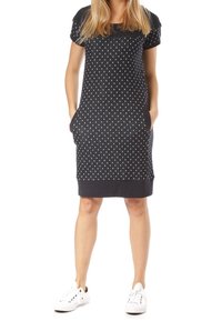 Ciemnoniebieska sukienka w białe kropki, z krótkimi rękawami, kieszeniami i prążkowanym dołem. Noszona z białymi trampkami dla uzyskania casualowego wyglądu.