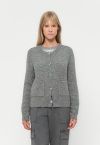 Grå strikket cardigan med rund hals, knapplukking, to frontlommer og myk tekstur. Stylet med grå cargo bukser.