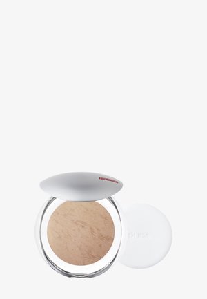 Compactpoeder met een doorzichtig rond doosje, zilveren ovale deksel en lichtbeige poeder met een gestructureerd oppervlak. Inclusief een wit aanbrengkussentje.