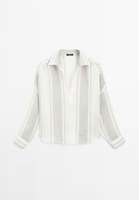 Chemise en lin à manches longues avec des rayures verticales beige clair et blanc, col ouvert et coupe ample sur fond blanc uni.