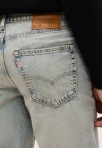 Φωτεινό μπλε τζιν με κέντημα στην πίσω τσέπη και καφέ δερμάτινο ετικέτα με το μέγεθος W31 L32 σ τη μέση.