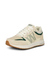 Baskets de sport beiges avec des accents verts, en daim et en mesh, à bout rond, avec des lacets blancs et une semelle en caoutchouc d'ensemble.