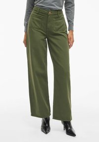 Pantaloni a gamba larga in tessuto verde oliva, a vita alta con chiusura frontale a bottone. Presentano due tasche anteriori e una superficie liscia.