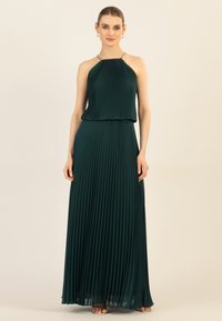 Plissiertes Maxikleid in tiefgrün, mit einem ärmellosen Halterneck-Ausschnitt und verzierten Trägern. Fließender Stoff mit glatter Textur.