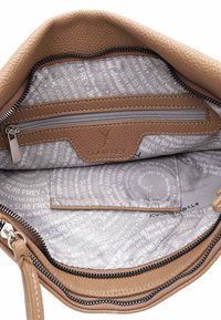 Intérieur d'un sac à main en cuir texturé marron avec une poche zippée et une doublure à motifs, affichant un texte gris sur un fond beige.
