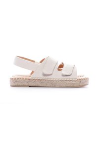 Sandalia de lona blanca con dos correas anchas y soporte en el talón. Suela de yute estilo espadrille, con un borde trenzado texturizado.