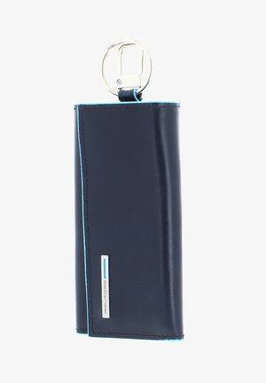 Marine leren portemonnee met een glanzende afwerking, voorzien van blauwe stiksels, een sleutelhangerbevestiging en een zilveren merklabel aan de zijkant.