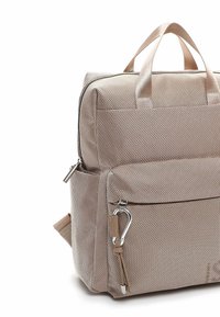 Bēšas auduma soma ar teksturētu virsmu, divām rokturiem, iekšējiem nodalījumiem, priekšējo rāvējslēdzēju kabatu un karabīnes sprādzīti papildu piestiprināšanai.