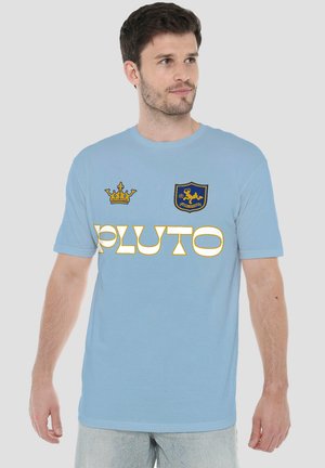 Man wearing light blue T-shirt with yellow crown and lion shield logos and the word "PLUTO" in bold white and yellow letters.
