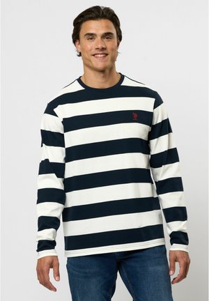 Langarm gestreept shirt in marineblauw en crème, gemaakt van zachte stof. Heeft een ronde hals en een klein rood logo op de borst.