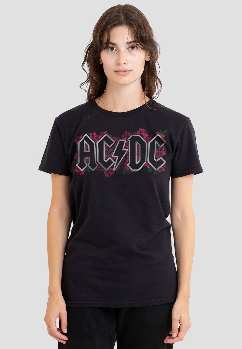 Schwarzes Baumwoll-T-Shirt mit einem grafischen Druck von "AC/DC" in Grau, umgeben von Rosen. Klassischer Rundhalsausschnitt und kurze Ärmel.