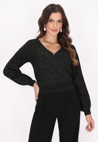 Maglione nero scintillante con scollatura a V, maniche lunghe a sbuffo, vita aderente e polsini a costine. Vestibilità standard, realizzato in tessuto morbido e texture.