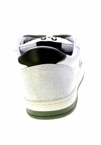 Sneaker bianco con texture crepata sul tallone, dettaglio del collettore nero e suola scura, visto da dietro.