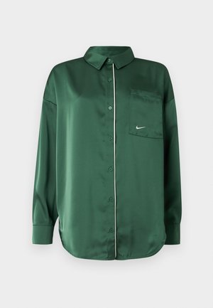 Chemise en satin vert avec un col à revers, une poche avant et un liseré blanc le long de la patte de boutonnage ; manches longues et ourlet arrondi.