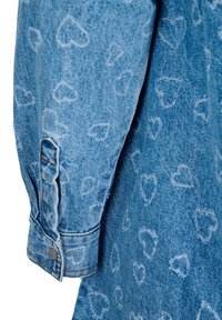 Denim košulja s rukavima u svijetloplavoj nijansi s utisnutim uzorkom srca. Manžetne uključuju detalj s srebrnim dugmetom.