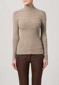Beige høyhalset genser med horisontal ribbestruktur på overkroppen og vertikal ribbing på sidene. Tettsittende design, lange ermer.