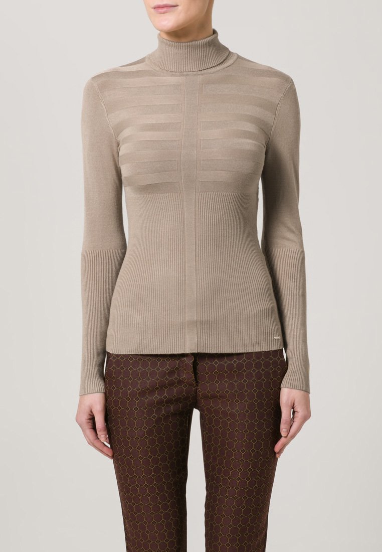 Beige høyhalset genser med horisontal ribbestruktur på overkroppen og vertikal ribbing på sidene. Tettsittende design, lange ermer.